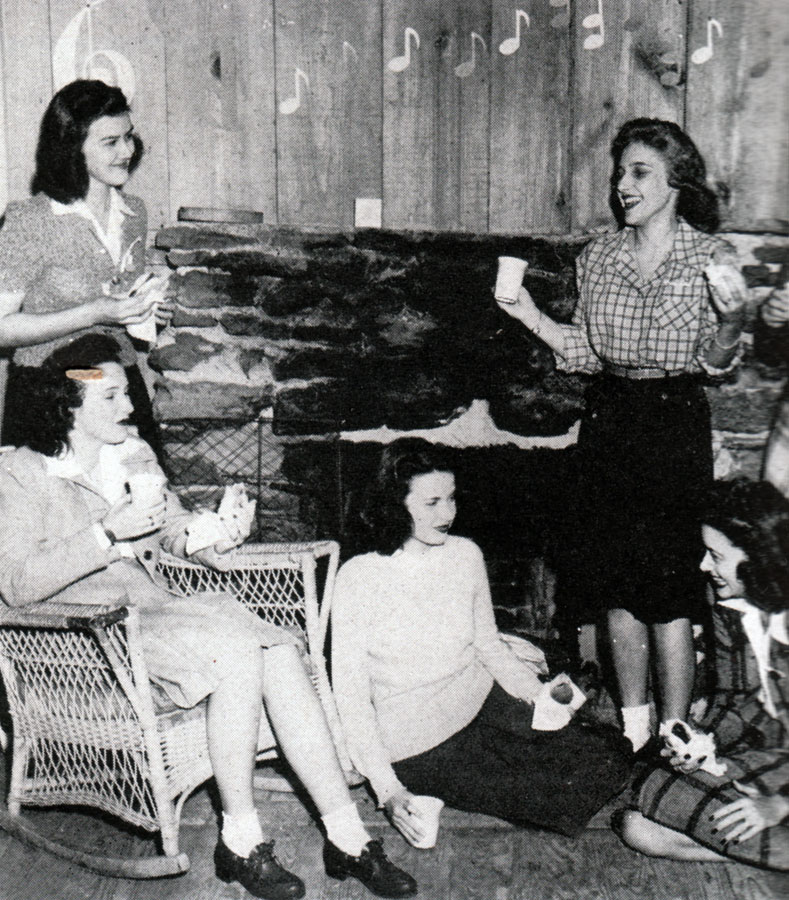 1940s vintage party photo of a group of grils in 1940s hairstyles and 1940s fashions enjoying some time together