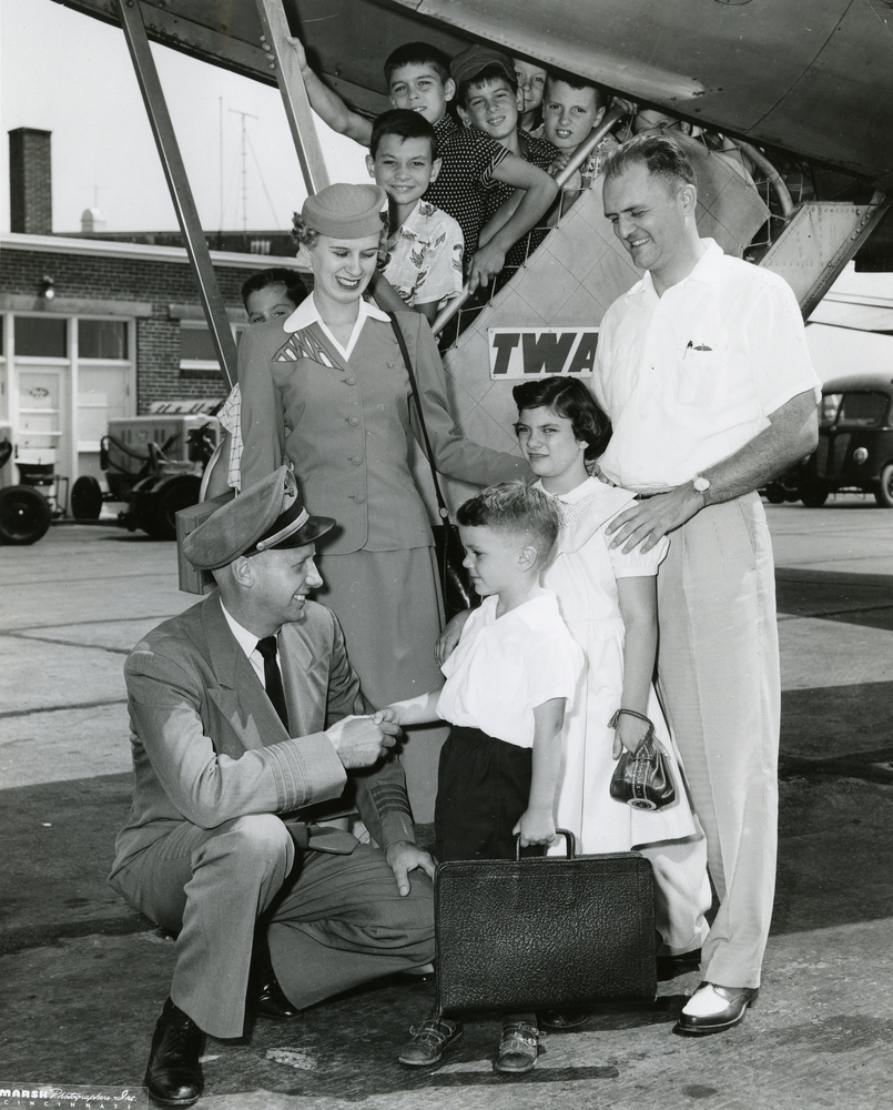 A TWA pilot and stewardess greets the passengers coming off the plane, ca.1950s, Cincinnati, Ohio