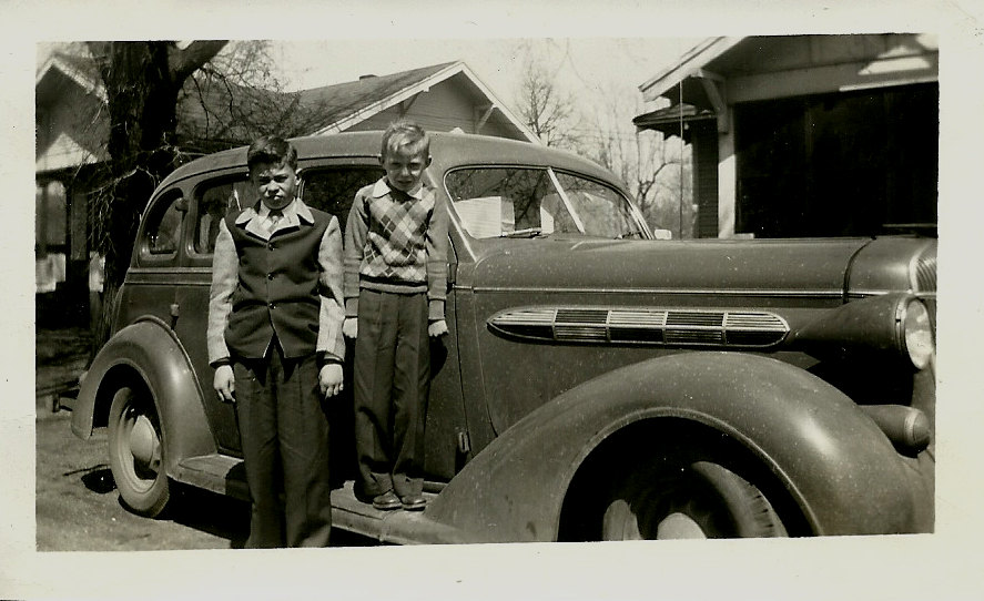 1940s Vintage Photo of 2 kids posing in front of a 1940s car in 1940s fashions.