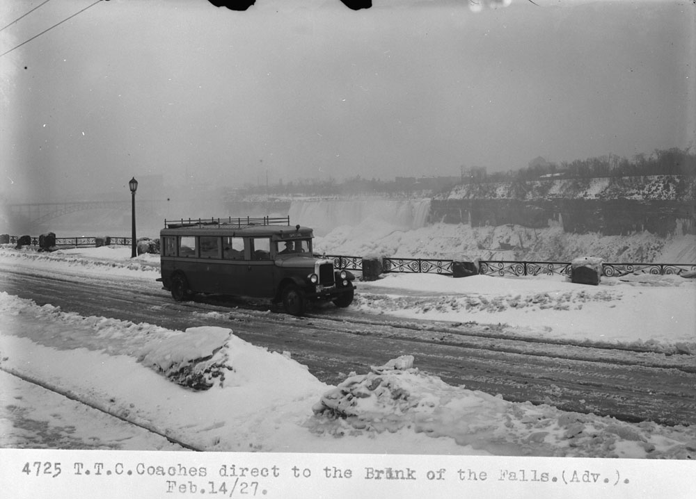 1920s photo: Niagara Falls in the Winter vintage image featuring a bus driving by the falls. 