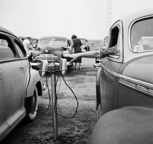 Vintage Image of cars at the Drive-In Movie Theatre with the speakers. 