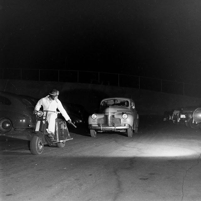 1940s vintage photo of a a drive in theatre in 1948 San Francisco usher on a motorcycle