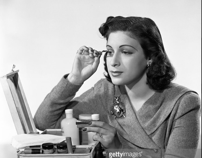 1940s Vintage Photo: Bea Wain, singer on CBS Radios popular music program, Your Hit Parade. Here, She applies makeup. Image dated October 1, 1940. New York, NY.