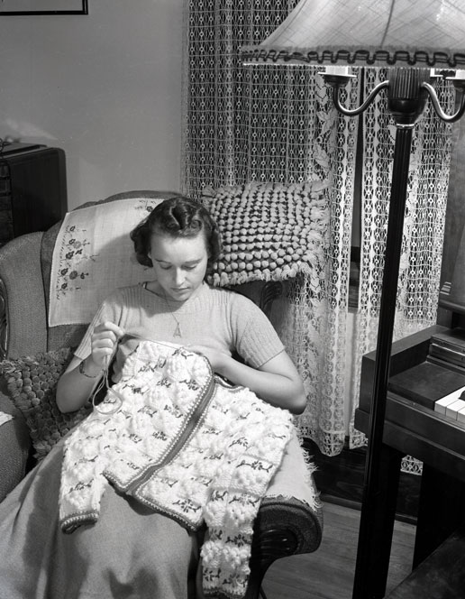 1940s Vintage Photo of a Canadian Woman crocheting a sweater in 1941. 
