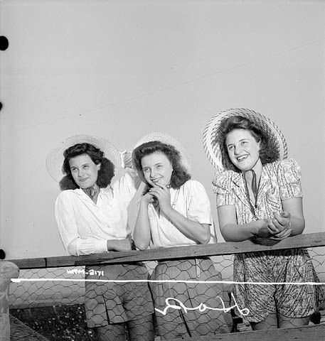 Women munitions workers of the Dominion Arsenals Ltd. plant hanging out with friends. 1942 WW2 Homefront Canada vintage photo. Plus 1940s hairstyle inspiration-How to wear a hat with your 1940s hair. 