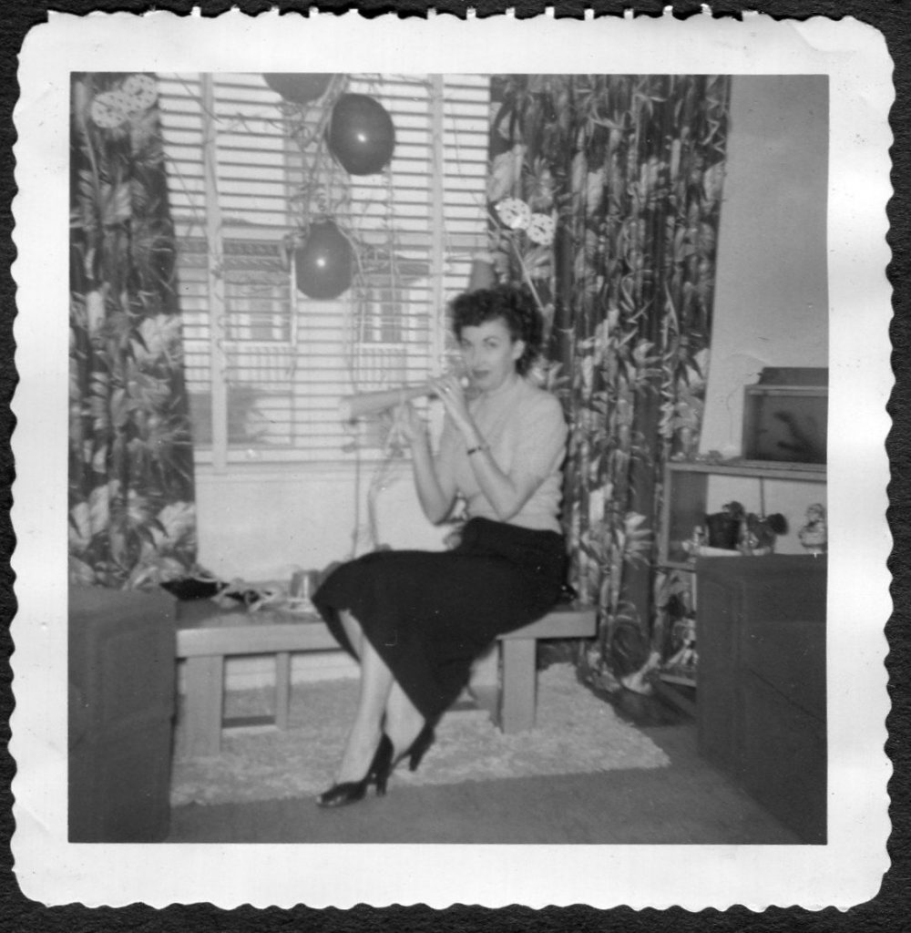 1950s Vintage New Years Eve Photo of a woman with a horn blower in a vintage house