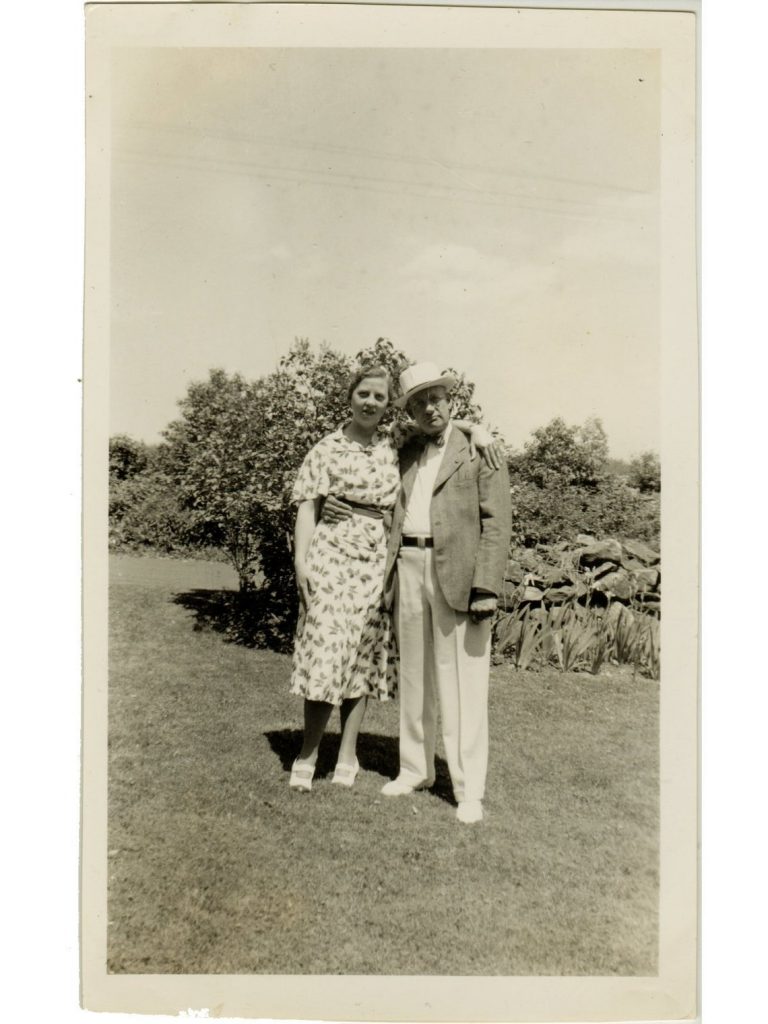 1930s vintage photo of an older couple standing in a garden