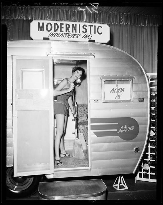 1950s vintage photo of a woman / model sweeping inside an Aljoa Trailer at a show. 