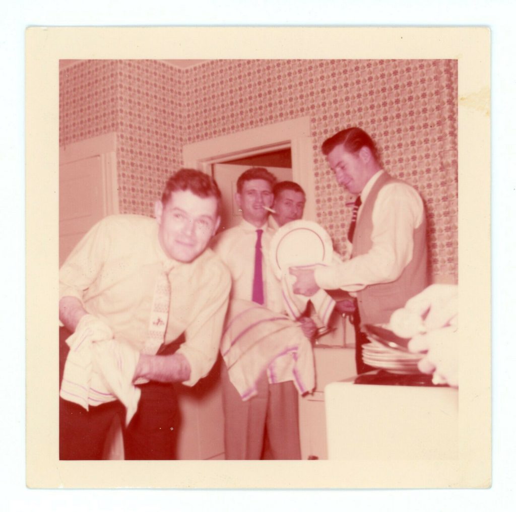 1950s vintage photo of 1950s men washing dishes in the kitchen smoking