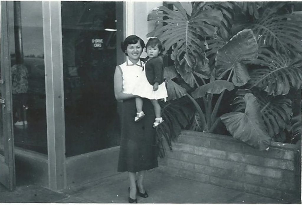 1950s Vintage Photo of a young Asian mother in 1950s fashion holding her daughter.