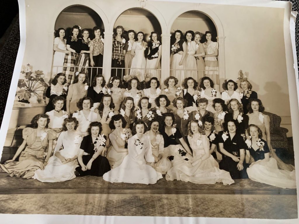 1940s vintage photo of a group of women all dressed up for an event with corsages and 1940s dresses and 1940s hairstyles