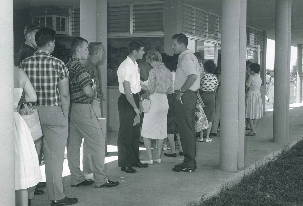 1950s vintage photo of student registration at Palm Beach Junior College 1950s fashions for men and women on display