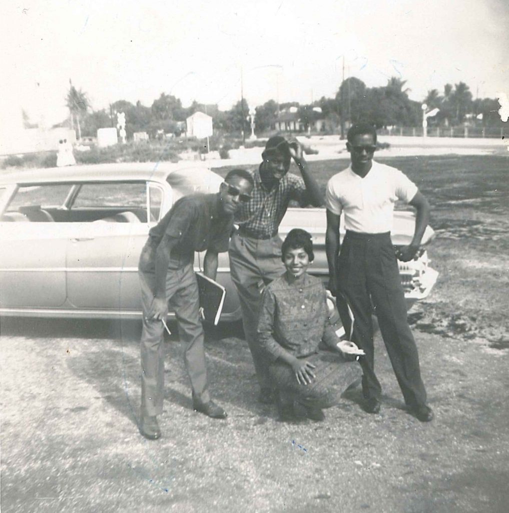 1960s vintage photo seen in a 1961 Yearbook of 4 Black students. Photograph of four students with caption "Miss Freshman of 59 & 60 pose with classmates". The Hornet (1961) page 30. Number 106 of 192 from archival box labeled Roosevelt Junior College Photographs. 