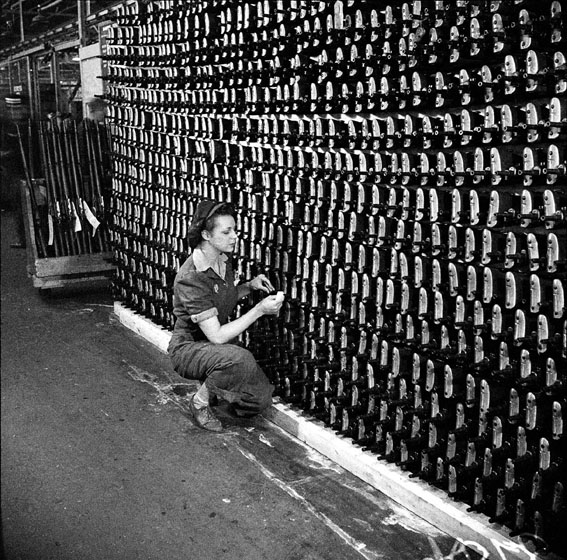 1940s vintage photo from 1943 of a women working at the Small Arms Inspection Building / Small Arms Manufacturing plant during WW2 in Mississauga, Ontario Canada. She is doing her part for the Home front. 
