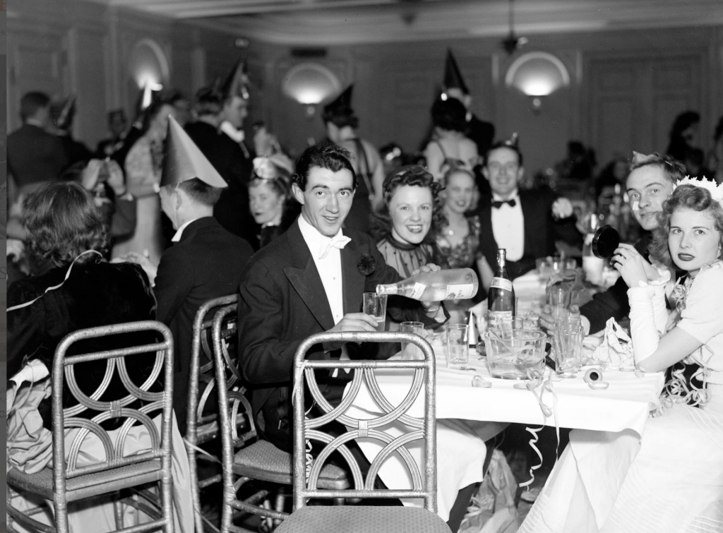 1940s vintage photo of a stylish New Years Eve Party. stunning 1940s fashions and 1940s hairstyles for women and men