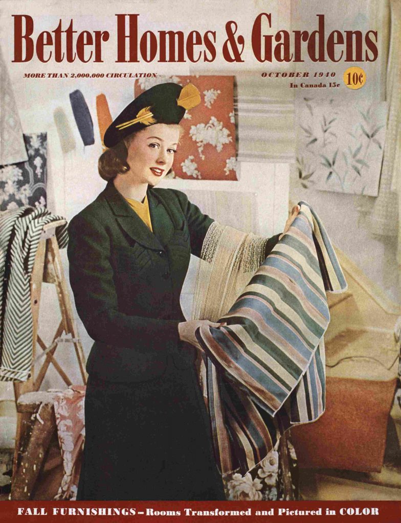 1940s vintage magazine cover for Better Homes & Gardens October 1940 featuring a stylish women in a two piece suit and a 1940s hat holding fabrics for her home decor