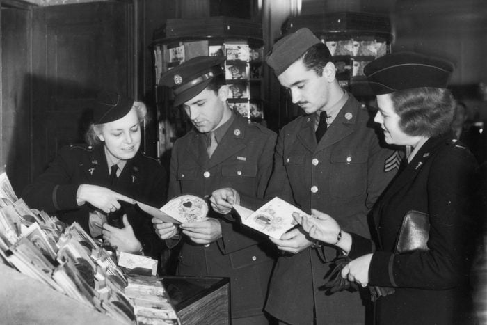 1940s vintage photo of US soldiers looking at valentines day cards to send back home in 1943