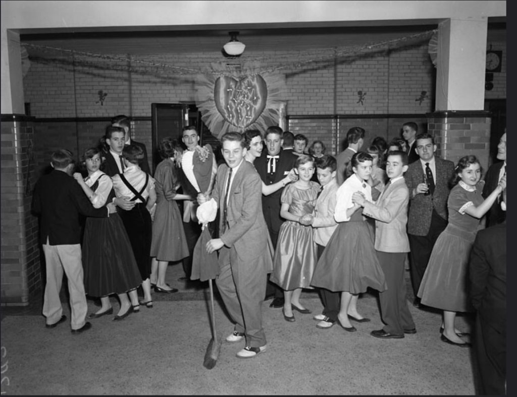 1950s vintage photo of a group of young teenagers at a school dance. 