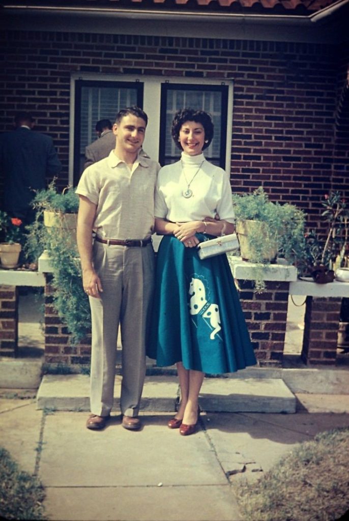 1950s Fashion-Woman wearing a 1950s circle skirt with a horse on the front, turtleneck sweater and long necklace.