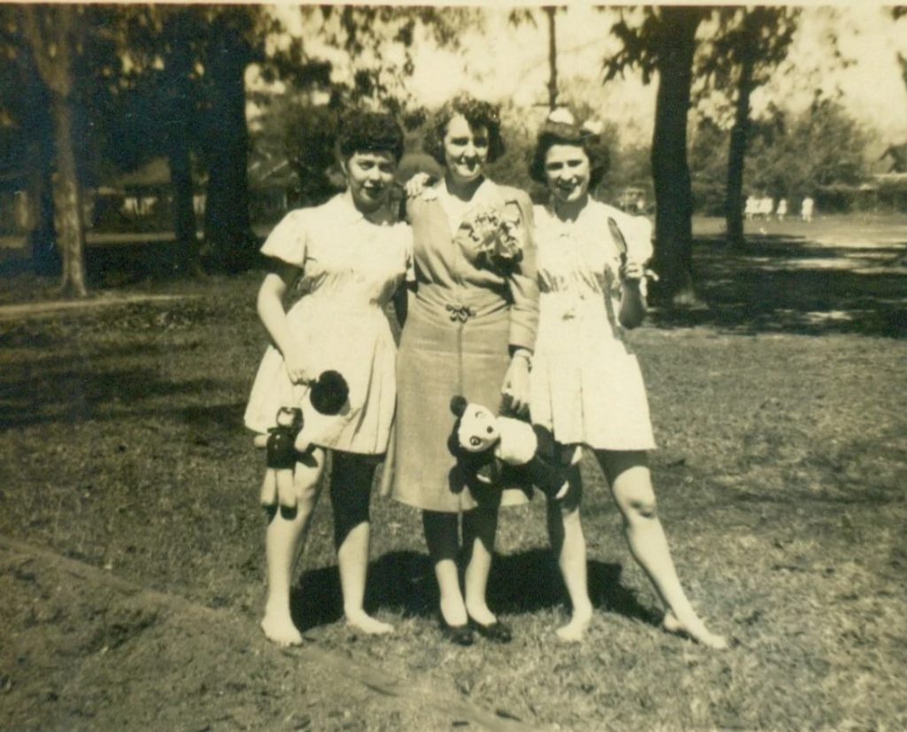 1940s photo: A mother poses with her daughters at a party in the summer of 1944. They are holding paddles and stuffed toys, maybe something they won??  I also love the 1940s curly hairstyles on all our ladies. 
