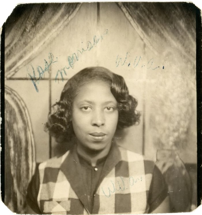 1950s vintage photo of a pretty young Black Women in a photobooth with a 1950s hairstyle and plaid vest