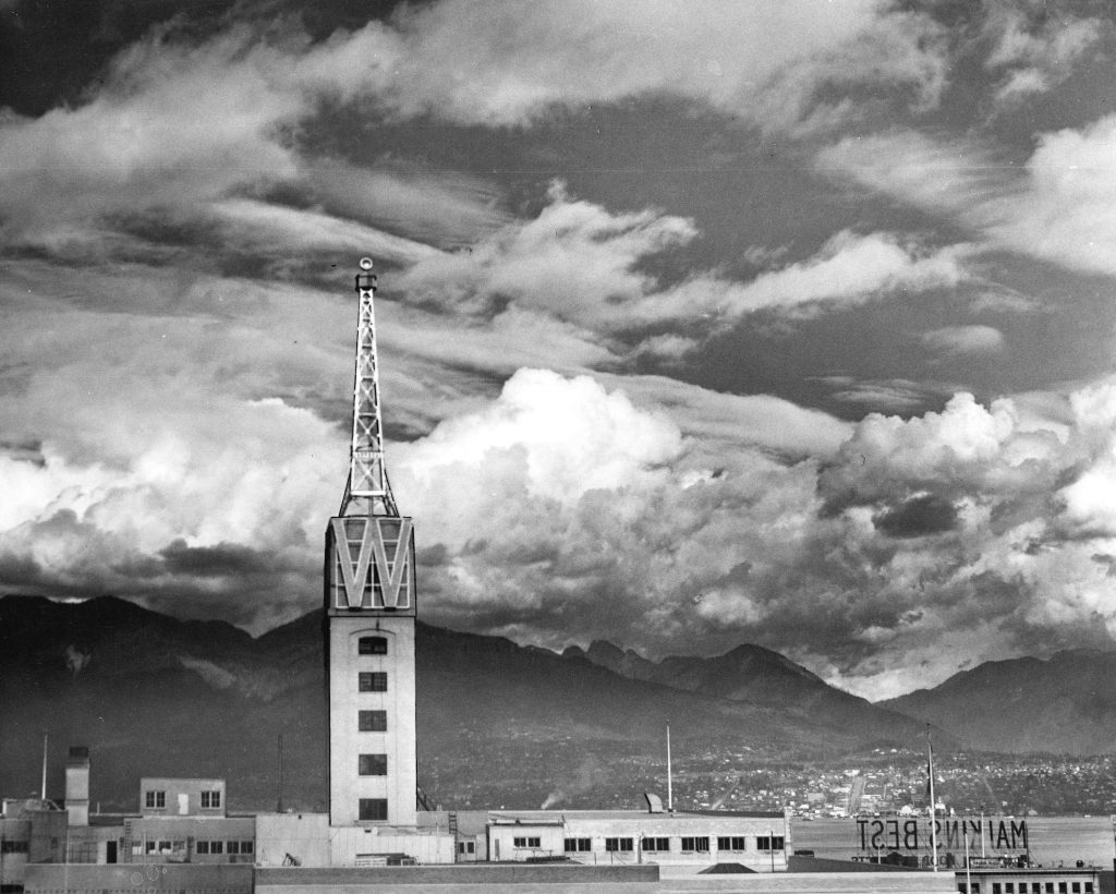 1930s vintage photo: The Woodward Beacon. In 1927, Percival Archibald Woodward (VP of Woodward) built a 75-foot-high beacon to act as a giant billboard advertisement for the department store. The tower held a searchlight that threw out a two million candlepower beam which revolved six times each minute and could be seen from Vancouver Island. 