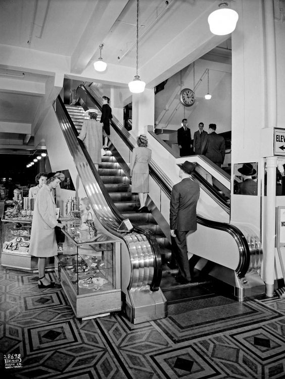 1940s vintage photo of shoppers in a Woodward's Department store in Canada, 1945 shopping and going up an escalator. 