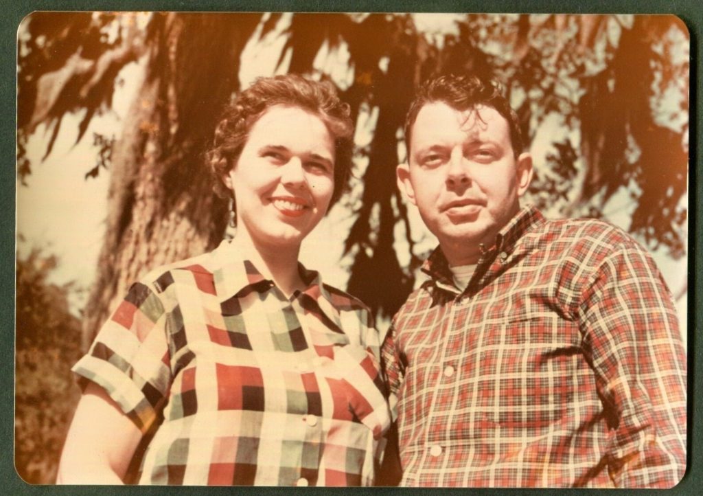 1950s photo of a couple in plaid shirts posing together outside. Love the Ducktail hairstyle on our man. Fun 1950s Fashion inspiration. 