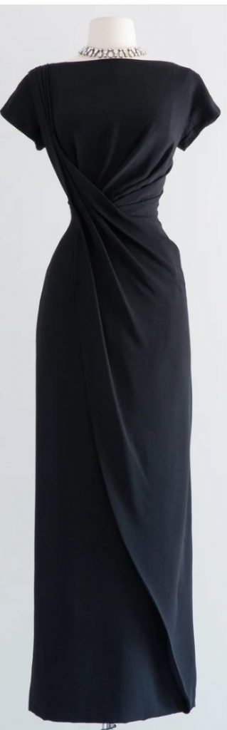 1950s Fashion: Black evening gown from the late 1950's by renowned designer Dorothy O'hara. Beautifully constructed with her signature draped bodice in a black rayon crepe