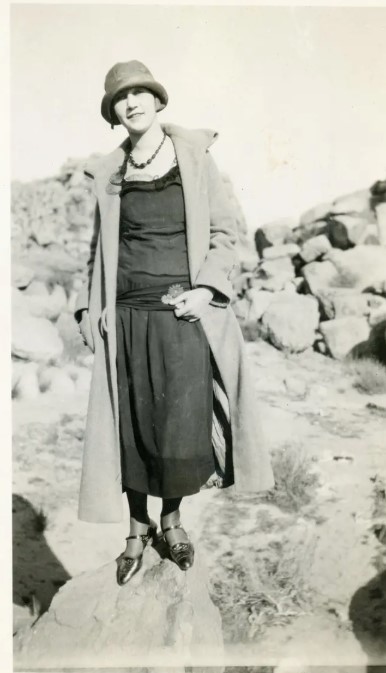 1920s vintage photo of a woman in a 1920s dress and 1920s hat, a cloche hat. 