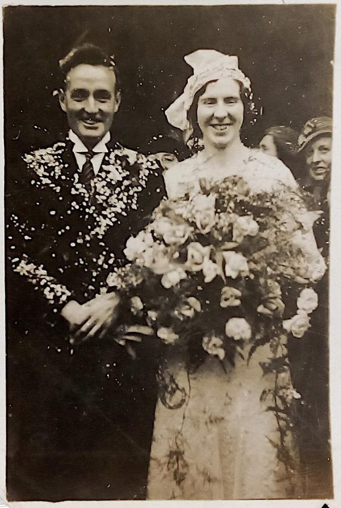 1930s vintage photo of a 1930s couple smiling after their wedding and all the confetti that was thrown on them. Great 1930s vintage wedding photo. 