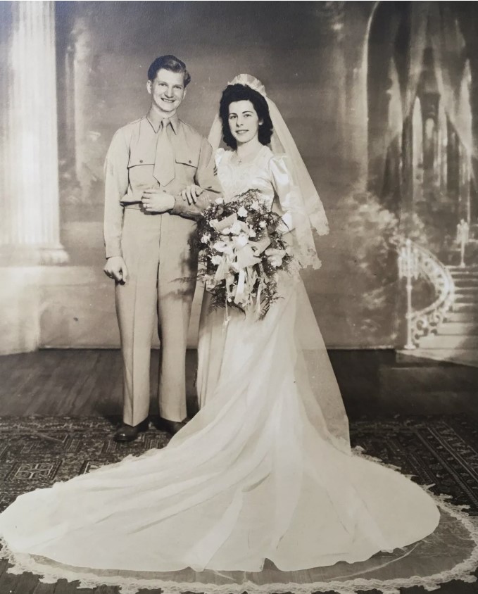 1940s vintage photo of a bride and soldier groom posing for their photo on their wedding day. 