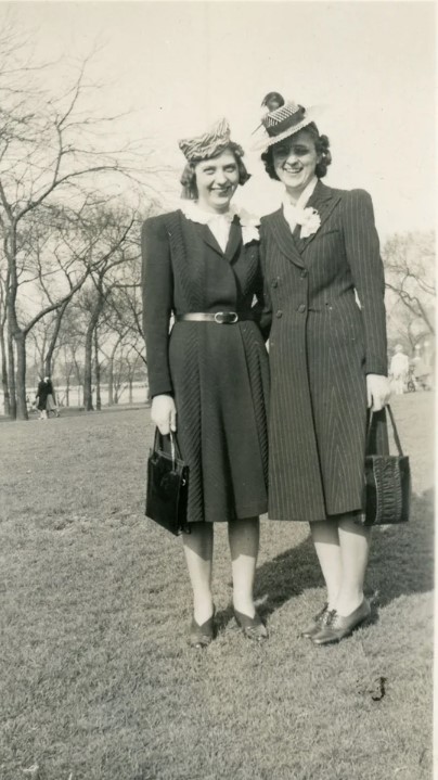 Late 1930s, early 1940s photo of two friends smiling together with matching corsages and very fun hats. Fantastic vintage fashion inspiration. 