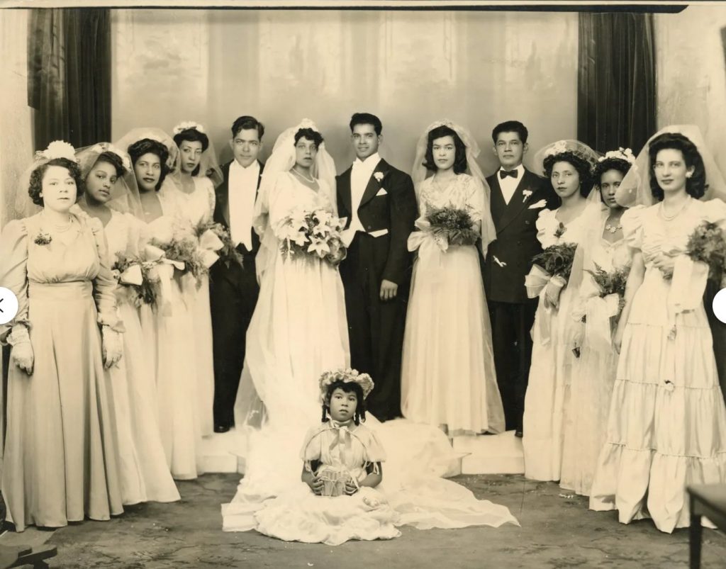 1940s Wedding Photo / Vintage Wedding photo featuring a large wedding party featuring the bride and groom, bridesmaids, groomsman and flower girl. 1940s wedding dress/ 1940s bridesmaid dresses. 