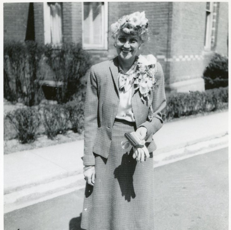 1950s / 1960s vintage photo of a woman looking to be wearing her best Easter Outfit including a large corsage and an Easter Hat. She is wearing a two piece suit.