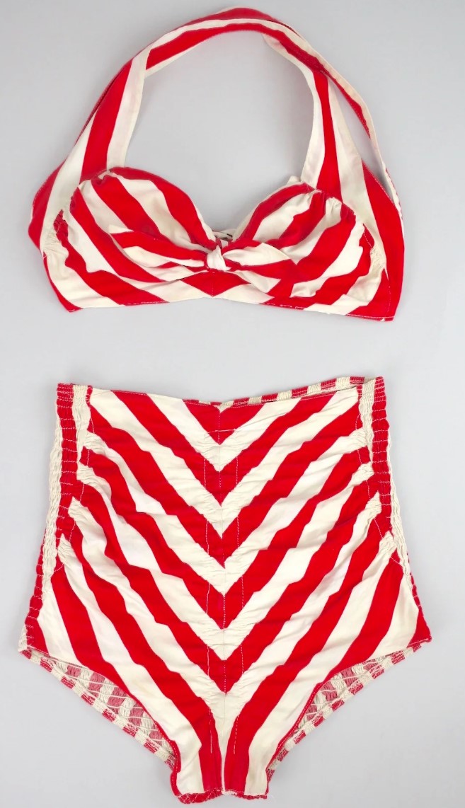 1940s Fashion: 1940's Cole of California red and white striped 2 piece swimsuit. The top features a versatile design - it can be converted into a halter top or it can be worn a spaghetti strap. Two buttons on either side (with two button holes) allow you to change the way the straps can be worn.