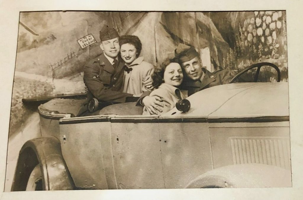 1940s vintage souvenir photo from Coney Island featuring two men in military uniforms posing with two women in a car. Fun shore leave photo. 